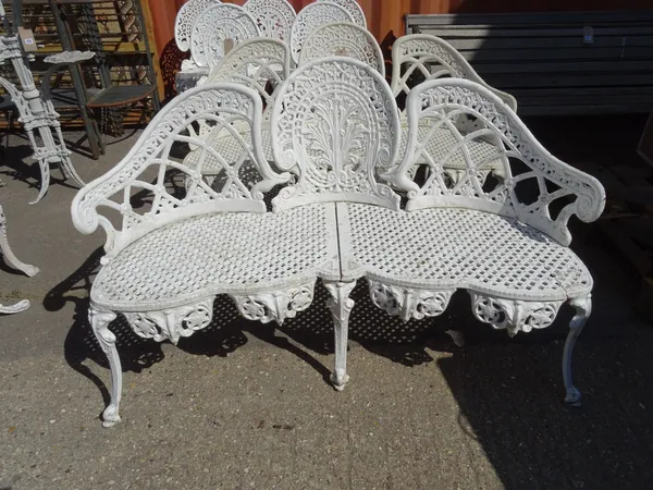 Garden furniture, comprising; a pair of 20th century white painted cast iron serpentine garden benches, 135cm wide, (2).   OUT
