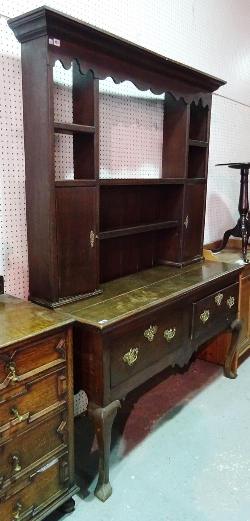 A mid-18th century style oak dresser, the plate rack incorporating a pair of cupboards over a two drawer base on pointed cabriole supports, 153cm wide