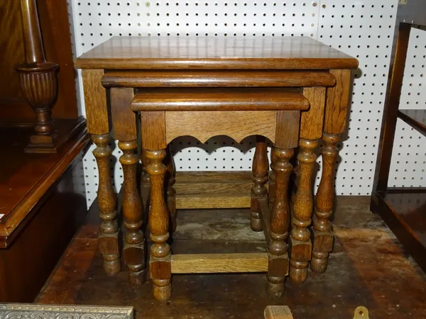 A nest of three oak occasional tables on baluster supports, the largest 61cm wide, (3).  J10