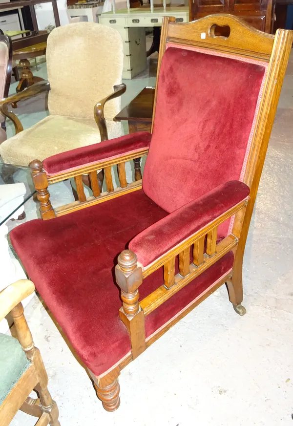 An Edwardian oak framed low armchair on ring turned supports and a late Victorian mahogany framed open armchair with carved frieze and cane back, (2).