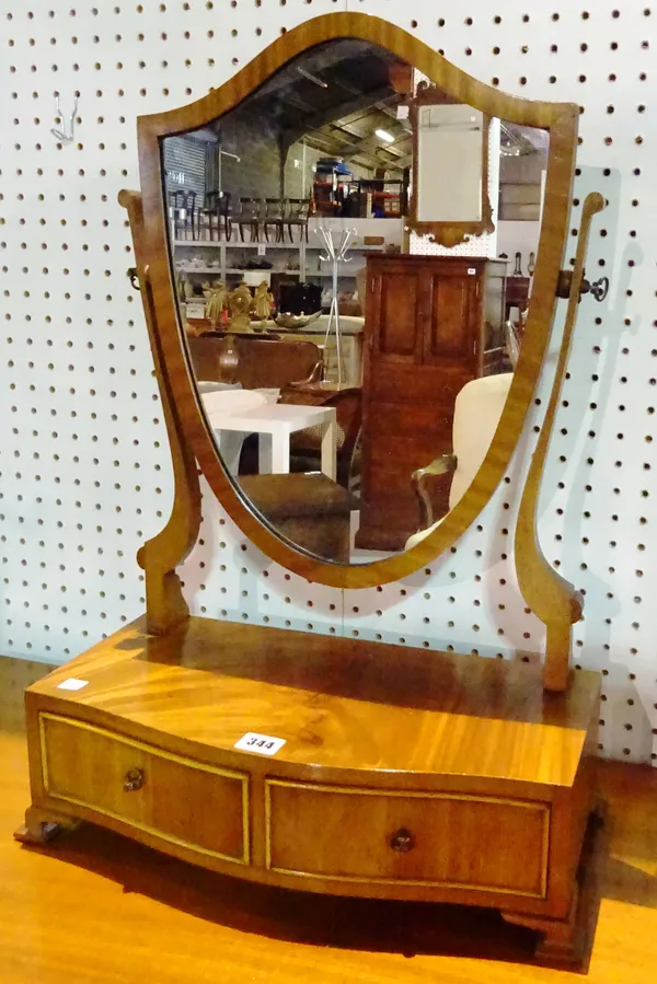 A George III style mahogany bowfront shield shaped dressing mirror with two drawer base, 44cm wide x 67cm high.  A6