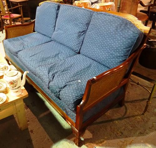 A 20th century mahogany framed bergere suite comprising a sofa and two low armchairs on ball and claw feet, (3).   BAY 1