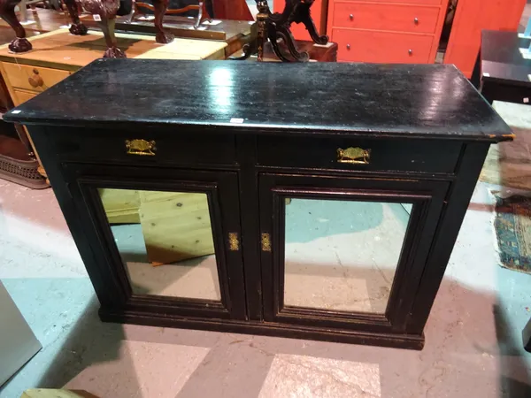 An early 20th century ebonised side cabinet with two drawers above two mirrored cupboard doors, 133cm wide x 92cm high. G10