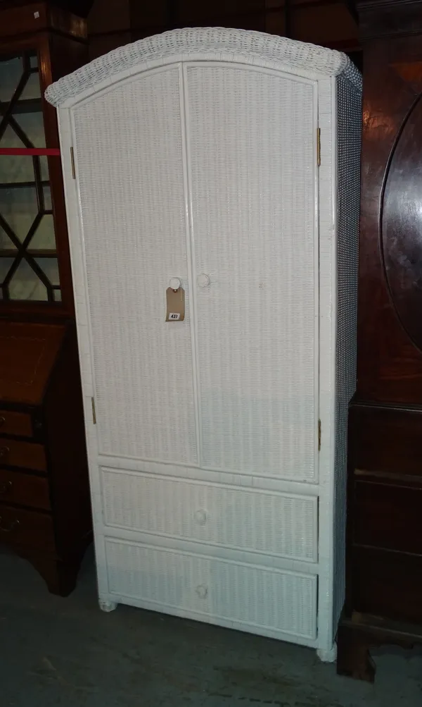 A 20th century white painted wicker arch top two door wardrobe, with two short drawers, on bun feet, 80cm wide x 175cm high.  M7