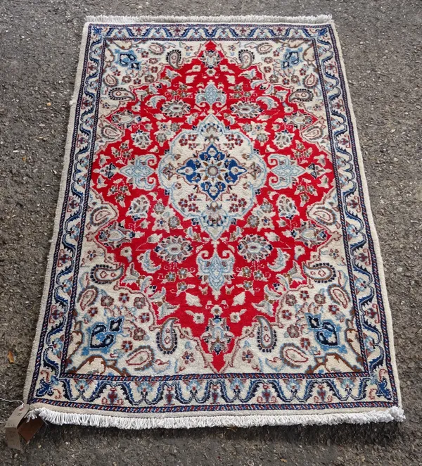 A part silk Esfahan rug, Persian, the madder field with a cream medallion and spandrels, all with floral sprays, a cream leaf border, 136 x 90 and a S