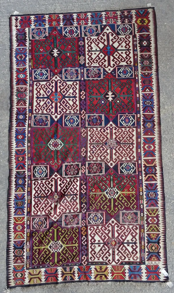 A Persian gelim, the polychrome field with five pairs of bold squared medallions, each with a stylised cross; an ivory lozenge border, 343cm x 189cm.