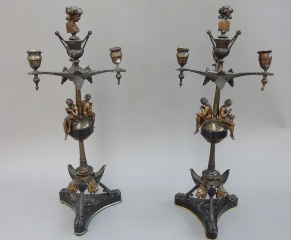 A pair of patinated bronze three branch candelabra, late 19th century, each with female bust finial and opposing piccolo players to the knopped stem,
