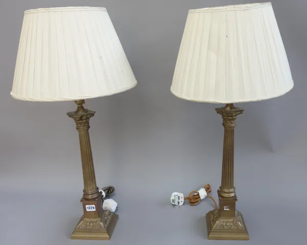 A pair of Victorian style brass table lamps, each of Corinthian column form, with cream silk pleated shades, 44cm high excluding fitments, (2).
