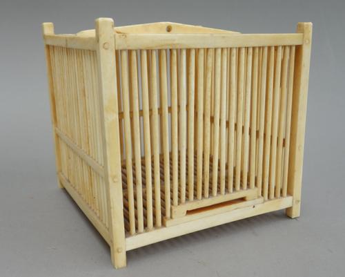 An ivory cricket cage of square form, circa 1900, with sliding door to one side, 12cm square.