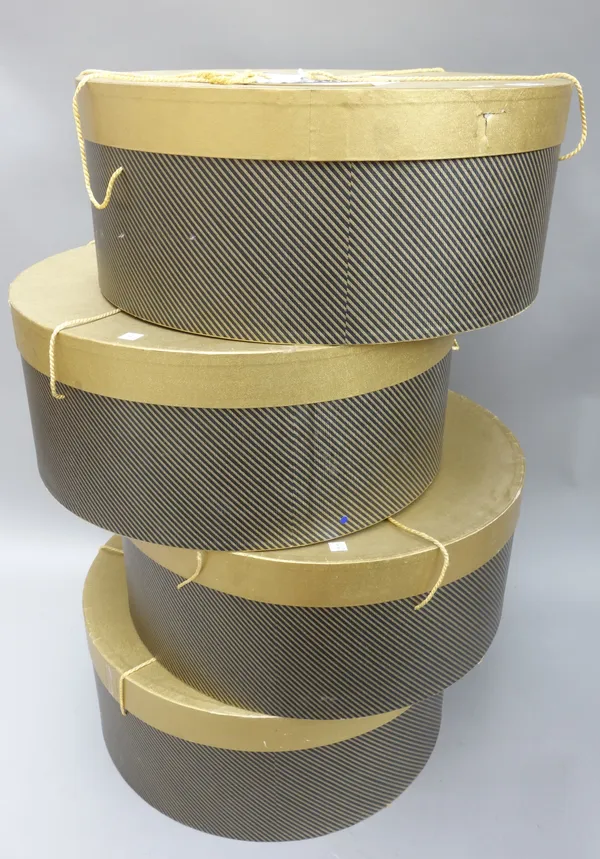 A set of four lady's hat boxes, modern, each gilt coloured with millinery paper labels and gilt cord, 50cm diameter, (4).