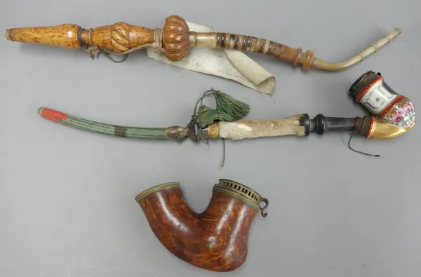 An Austrian porcelain pipe bowl, an Austrian burr maple carved pipe, and one further 19th century Continental wooden pipe bowl with metal mounts, 12cm