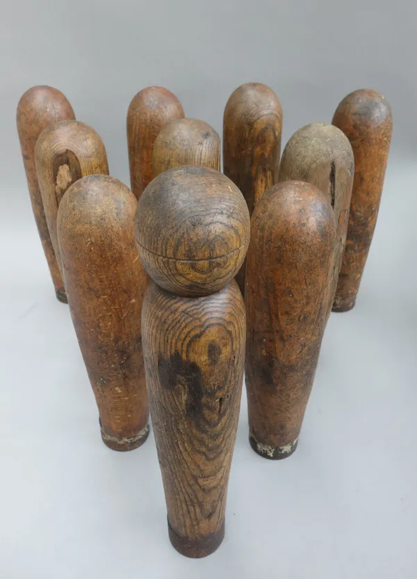 An early 20th century ten pin pine skittle set, with wrought iron band to the bases, with five wooden balls, (a.f).