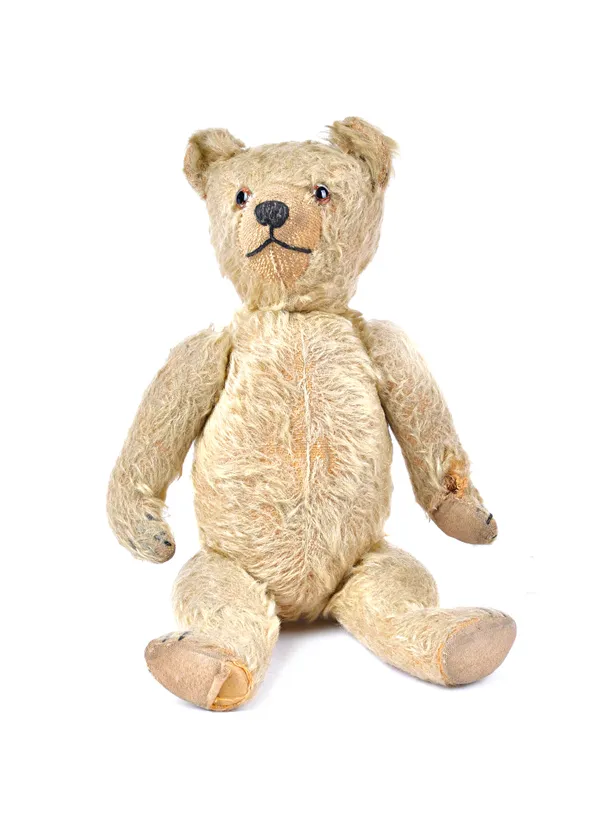 An early 20th century Steiff teddy bear, with golden fur, hump back and jointed limbs (a.f), 37cm long. Illustrated
