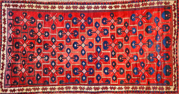 A Kirgiz kelleh, the madder field with interconnecting crosses, each bearing a stylised indigo cross, a neutral flowerhead and vine border, 298cm x 15
