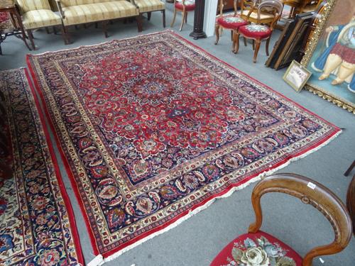 A Sarough carpet, Persian, the madder field with a large faceted medallion, indigo spandrels, all with intricate floral vine sprays, a dark indigo pal