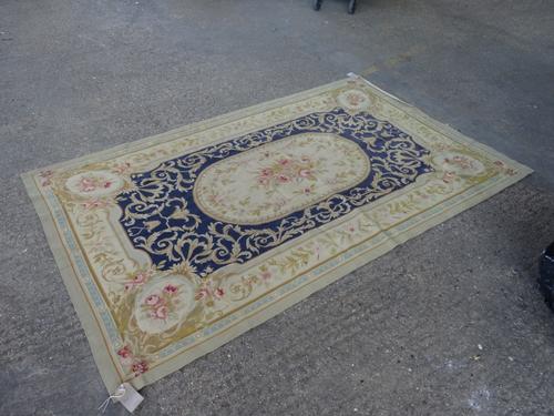 A tapestry rug, the dark indigo field with a floral central medallion acanthus sprays; a floral outer border, 245cm x 150cm. .