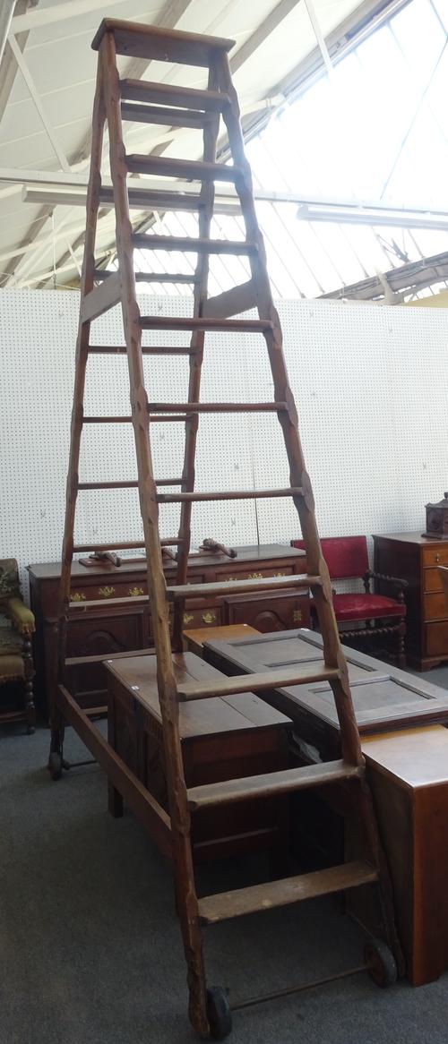 A set of late 19th/early 20th century pitch pine 'A' frame double sided ten rung library steps, 200cm wide at the base, 312cm high.