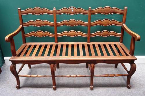 A 19th century provincial French oak triple chair back settle, on scroll supports united by turned stretcher, 150cm wide x 98cm high.