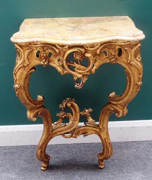 A small Louis XV style console, 19th century, the serpentine marble top over a carved and pierced gilt base, on a pair of opposing 'C' scroll supports