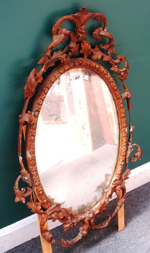 A mid-18th century gilt framed oval mirror, with egg and dart moulded frame and scrolling floral sprays, 67cm wide x 100cm high.