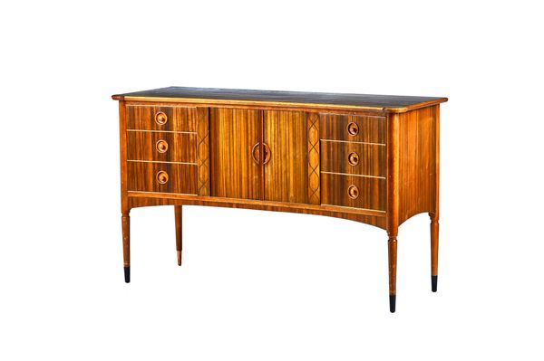 Attributed to Gordon Russell, a mid-20th century walnut concave fronted sideboard, with a pair of central tambour cupboards flanked by three drawers t