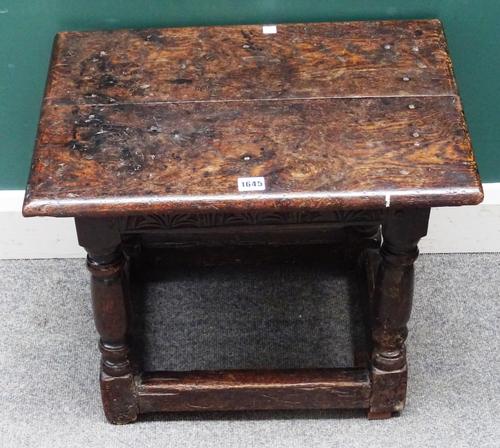 A mid-17th oak joint stool of large proportions, the twin plank top over lunette carved frieze, on turned supports united by perimeter stretcher, 55cm