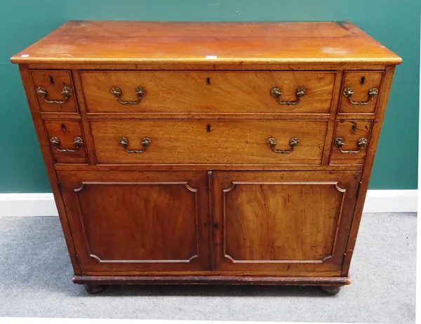 A George III mahogany side cabinet, with two long drawers flanked by four short over pair of cupboards, 118cm wide x 105cm high x 56cm deep.