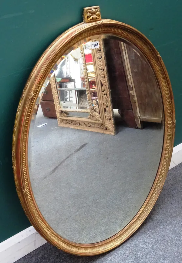 A 19th century gilt framed oval mirror, with ribbon tied moulded frame and bevelled plate, 80cm wide x 106cm high.