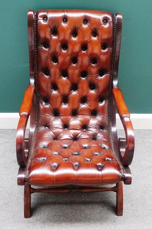 A Regency style slipper back library easy chair, with studded brown leather upholstery and open shepherd's crook arms, on 'X' framed base, 59cm wide x