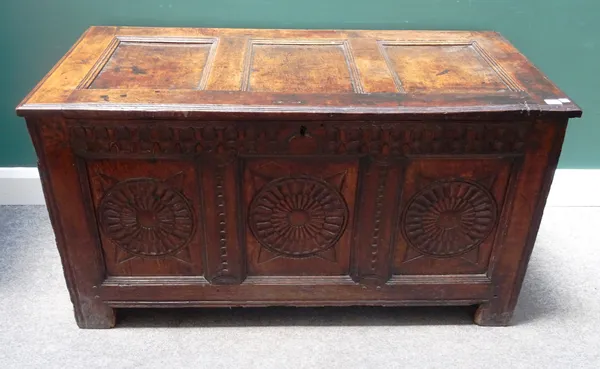 A 17th century oak coffer with triple panel lid and carved triple panel front on stile feet, 122cm wide x 67cm high x 59cm deep.