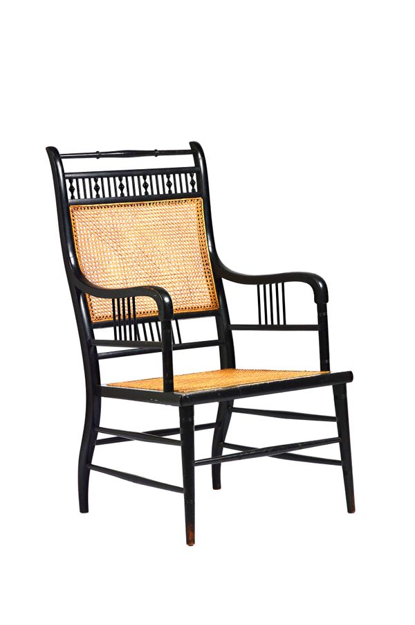 E.W. Godwin for William Watt; an Anglo-Japanese style ebonised beech and caned open armchair, on turned supports, 53cm wide x 94cm high Illustrated