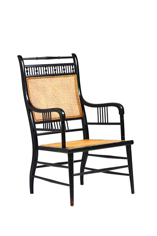 E.W. Godwin for William Watt; an Anglo-Japanese style ebonised beech and caned open armchair, on turned supports, 53cm wide x 94cm high Illustrated