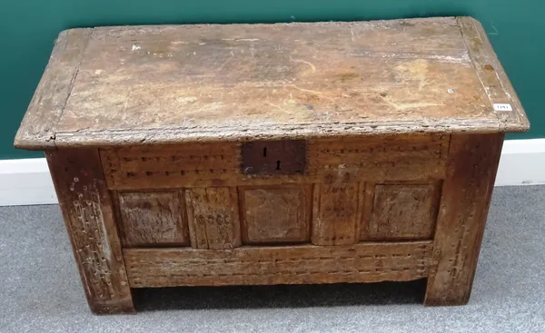 A 17th century and later oak coffer, the cleated slab top over triple panel fret front, on stile feet, 94cm wide x 55cm high x 43cm deep.
