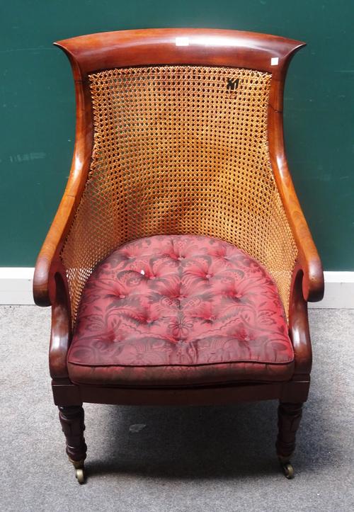 A William IV mahogany and canework tub back library bergere, on lappet carved supports, 58cm wide x 94cm high.