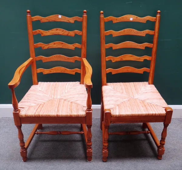 Willis & Gambier; a set of eight oak framed Lancashire ladder back dining chairs, with rush seats, on tapering turned supports, to include a pair of c