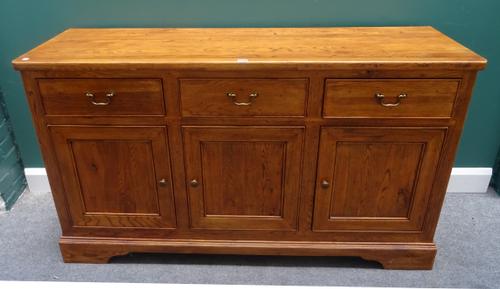 Willis & Gambier; an oak dresser base, with three drawers over cupboards, on bracket feet, 156cm wide x 89cm high x 50cm deep.