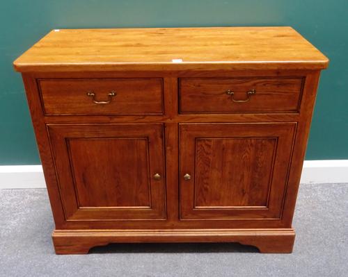 Willis & Gambier; an oak dresser base, with two drawers over cupboards, on bracket feet, 107cm wide x 89cm high x 49cm deep.