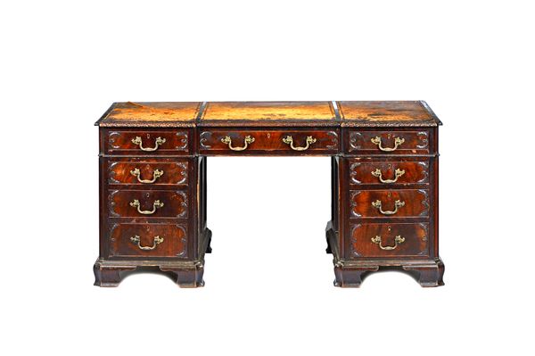 A mid-18th century style carved mahogany pedestal desk, the inverted breakfront top over nine drawers about the knee, on ogee bracket feet, 153cm wide