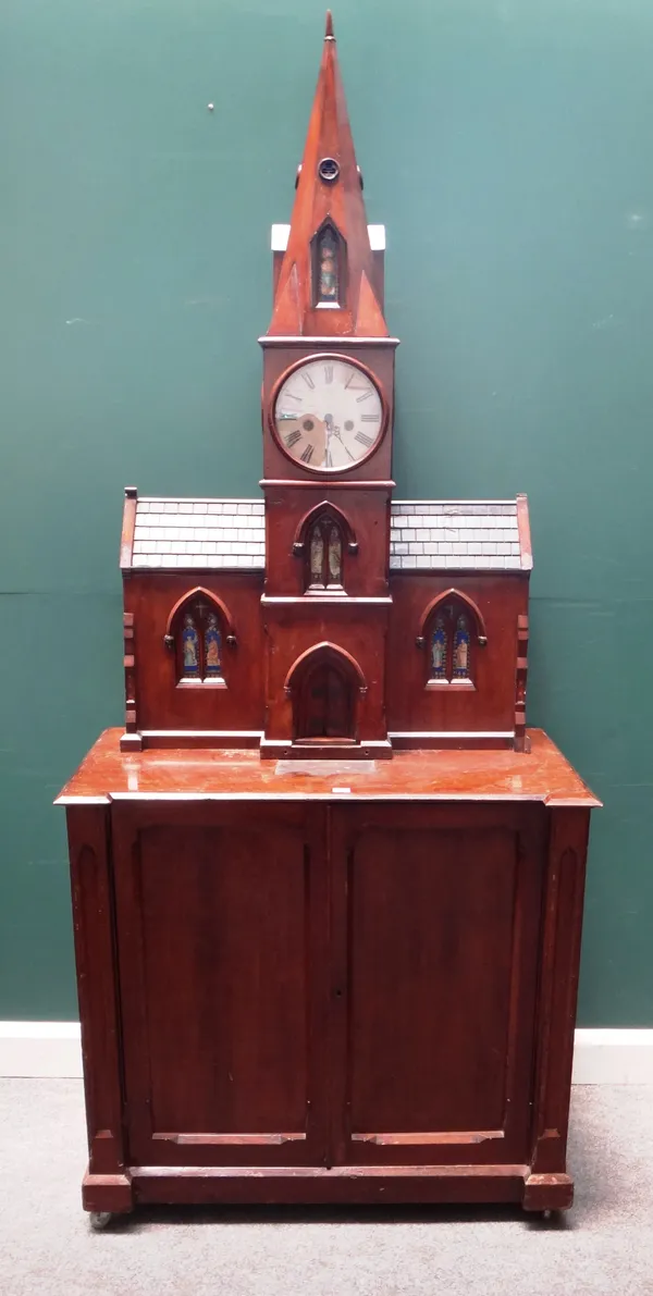 A 19th century Gothic Revival side cabinet, the upper section formed as a church with large clock tower, over a panelled two door base, 100cm wide x 2