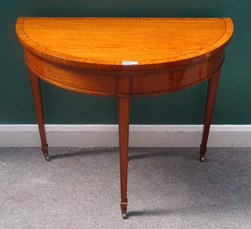 A George III style satinwood centre table, with semi-elliptic foldover top on tapering square supports, 91cm wide x 78cm high x 46cm deep.