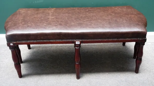 A 19th century mahogany stool, the rectangular leather upholstered seat over eight splayed and turned supports, 129cm wide x 55cm high x 58cm deep.