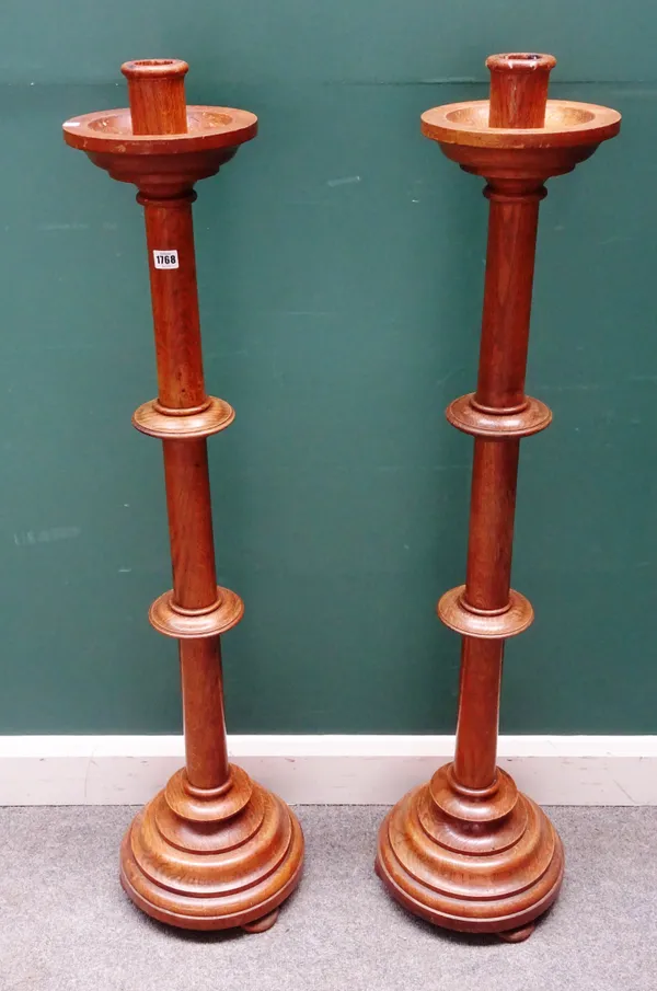 A pair of 20th century turned oak triple section floor standing candlesticks, on stepped circular bases, each 120cm high, (2).