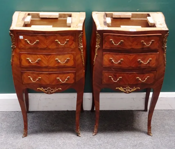 A pair of Louis XV style gilt metal mounted kingwood petite commodes, each with bombe three drawers on slender cabriole supports (the marble tops lack