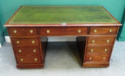 An early 20th century mahogany pedestal desk, with nine drawers about the knee, on a plinth base, 153cm wide x 83cm deep x 78cm high.