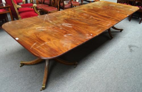 A Regency style mahogany twin pillar extending dining table, on eight downswept supports, to include two extra leaves, 117cm wide x 172cm long, 292cm