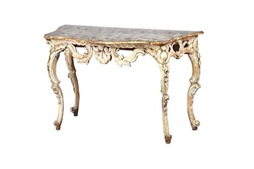 An 18th century Italian console table, the later serpentine painted faux marble top over a whitewashed carved and pierced base, on opposing 'C' scroll