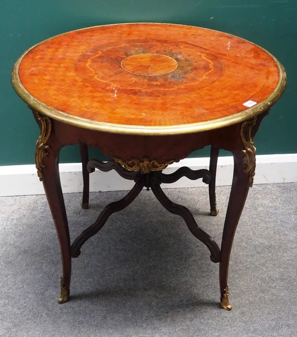 A late 19th century French kingwood occasional table, the circular cube parquetry inlaid top over a gilt metal mounted base, with four scroll supports