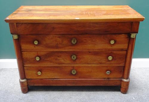 An early 19th century French gilt metal mounted walnut four drawer commode, with turned columns, 130cm wide x 90cm high x 57cm deep.