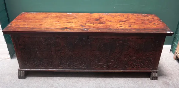 A large 18th century and later Middle Eastern cedar wood coffer, with plain lid and extensively carved front panel, on groove carved block supports, 1