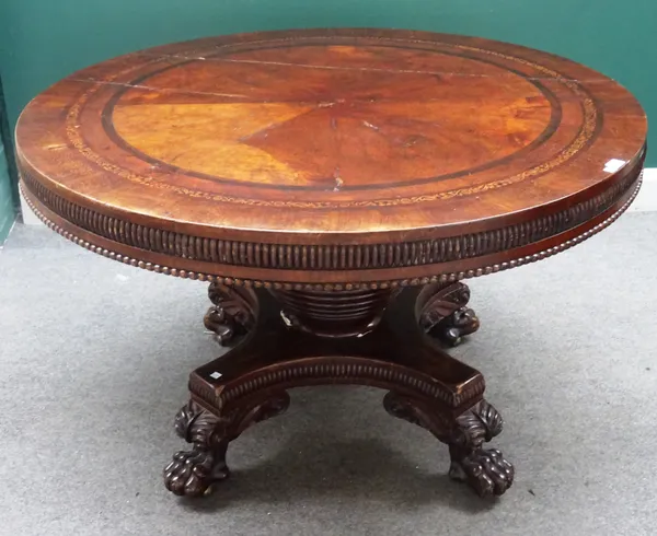 An early 19th century figured oak marquetry inlaid circular centre table, on bee hive column and four lion's paw feet, 123cm deep x 73cm high.
